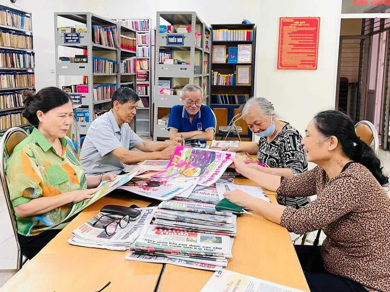 Bà Tuyên (ngoài cùng bên trái) và bà con làng Hồ ở phòng đọc sách. Ảnh: DƯƠNG THỊ PHÚC 