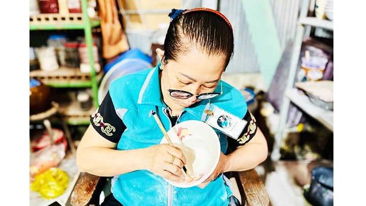 Chị Trần Thị Yến tỉ mỉ với nét vẽ truyền thống trên gốm Lái Thiêu.