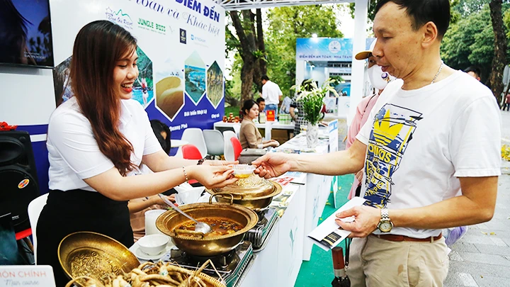 Giới thiệu sâm và các sản phẩm từ sâm Việt Nam cho du khách tại một hội chợ du lịch. Ảnh: KHIẾU MINH