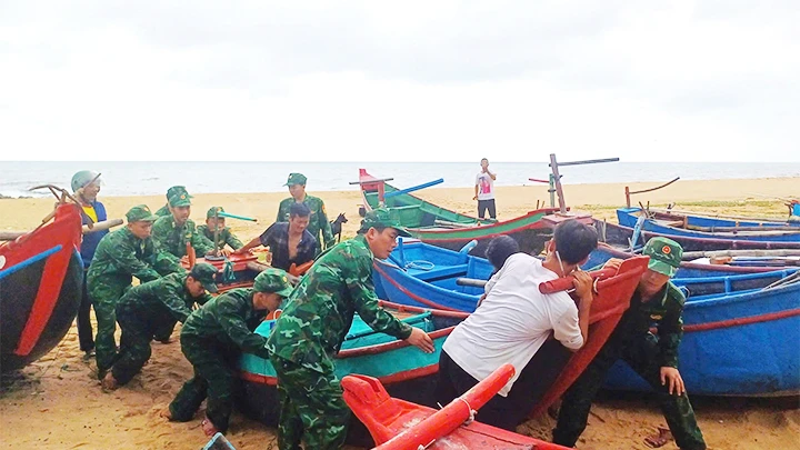 Bộ đội Biên phòng Quảng Bình giúp người dân chuyển thuyền đánh cá lên bờ chạy bão số 4.