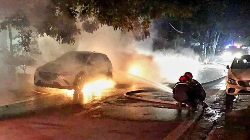 Lực lượng cứu hộ đang dập tắt đám cháy hai xe ô-tô trong đêm, ở thành phố Lào Cai.