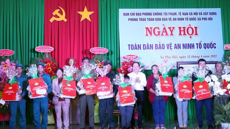 Đồng chí Lê Tiến Châu trao quà tặng các gia đình tiêu biểu trong phong trào toàn dân bảo vệ an ninh Tổ quốc xã Phú Hội.