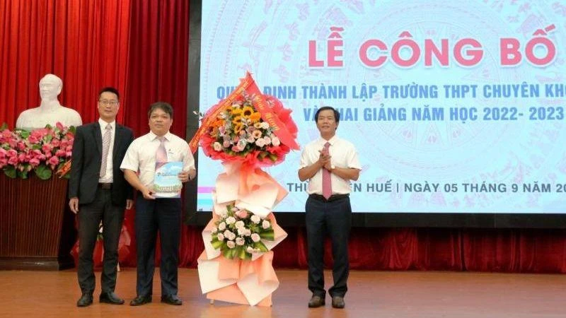 Chủ tịch UBND tỉnh Thừa Thiên Huế Nguyễn Văn Phương trao quyết định và tặng hoa chúc mừng nhà trường. (Ảnh: Trường đại học Khoa học cung cấp)