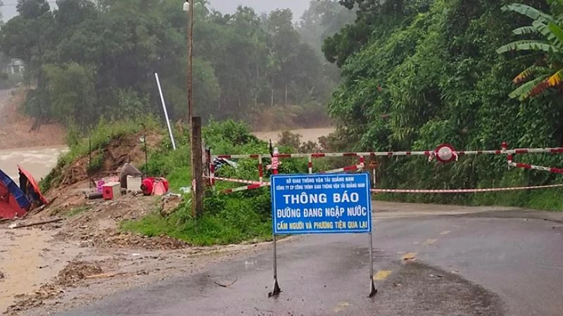 Cắm biển báo và giăng dây cấm người qua lại điểm ngập nước trên tuyến 14B, đoạn qua xã Trà Tân.