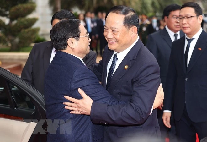 Thủ tướng Lào Sonexay Siphandone đón Thủ tướng Phạm Minh Chính. (Ảnh: Dương Giang/TTXVN)