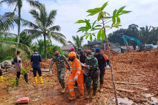 Lực lượng cứu hộ chuyển thi thể nạn nhân tại hiện trường lở đất ở đảo Serasan, tỉnh Riau, Indonesia. (Ảnh: AFP/TTXVN)