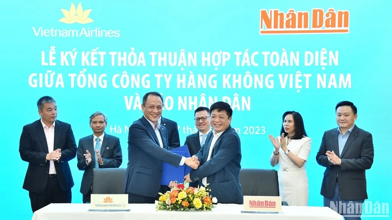 Phó Tổng Biên tập Báo Nhân Dân Quế Đình Nguyên và ông Lê Hồng Hà, Phó Bí thư Đảng ủy, Thành viên HĐQT, Tổng Giám đốc Vietnam Airlines trao nhau bản thỏa thuận hợp tác giữa hai 2 cơ quan trước sự chứng kiến của lãnh đạo 2 đơn vị.