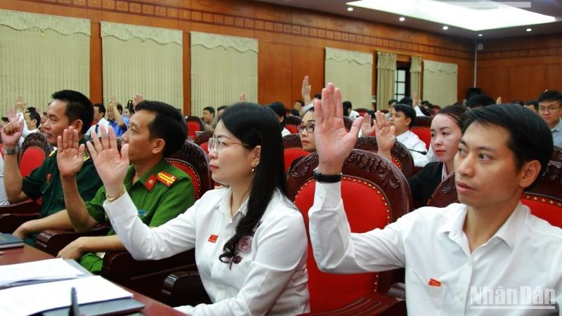 Các đại biểu Hội đồng nhân dân tỉnh Sơn La khóa 15 biểu quyết nhất trí thông qua các nghị quyết tại kỳ họp.