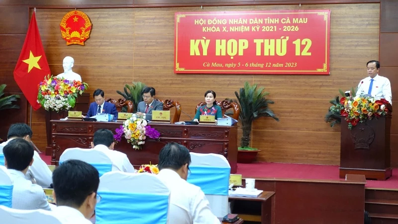 Chủ tịch Ủy ban nhân dân tỉnh Cà Mau Huỳnh Quốc Việt (bìa phải) trình bày báo cáo về tình hình phát triển kinh tế-xã hội năm 2023 và phương hướng, nhiệm vụ năm 2024.