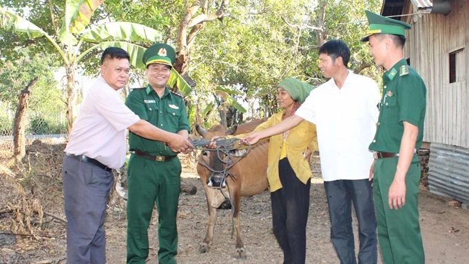 Thượng tá Rơ Lan Ngân, Phó Chính ủy Bộ đội Biên phòng tỉnh Đắk Lắk cùng đại diện các đơn vị trao tặng bò sinh sản cho bà H’Nhem Ê Ban tại xã biên giới Krông Na, huyện Buôn Đôn.
