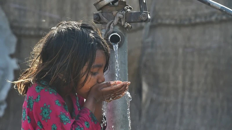 Em nhỏ uống nước từ vòi nước công cộng ở Lahore, Pakistan. (Ảnh: AFP/TTXVN)