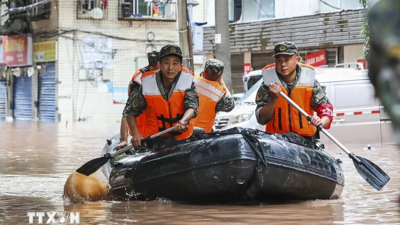 Cảnh sát Trung Quốc giúp sơ tán người dân khỏi các khu vực ngập lụt. (Ảnh: AFP/TTXVN)
