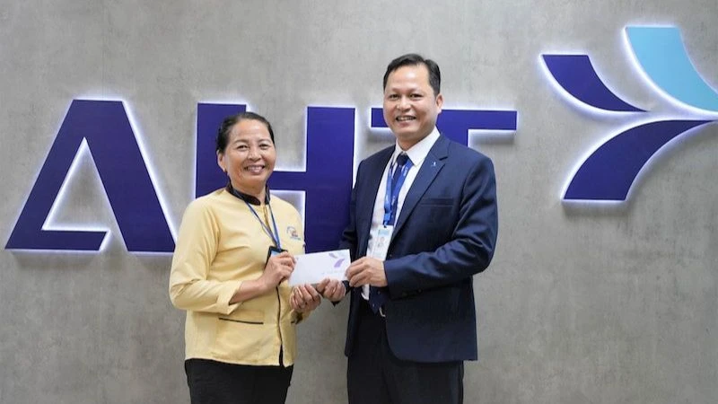 Đại diện Công ty cổ phần Đầu tư Khai thác Nhà ga quốc tế Đà Nẵng khen thưởng bà Trần Thị Hường.