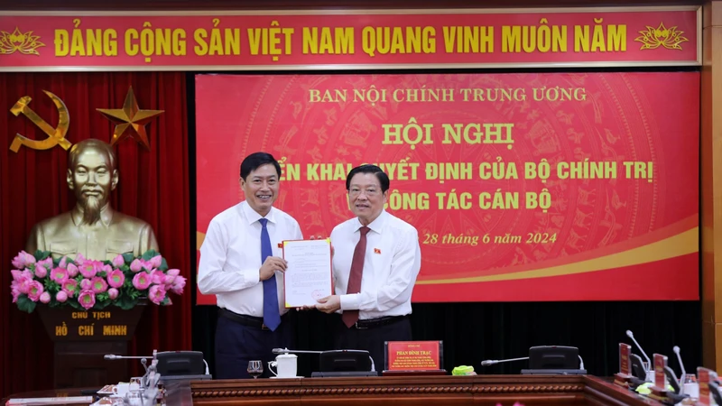 Đồng chí Phan Đình Trạc trao Quyết định của Bộ Chính trị cho đồng chí Nguyễn Hữu Đông.