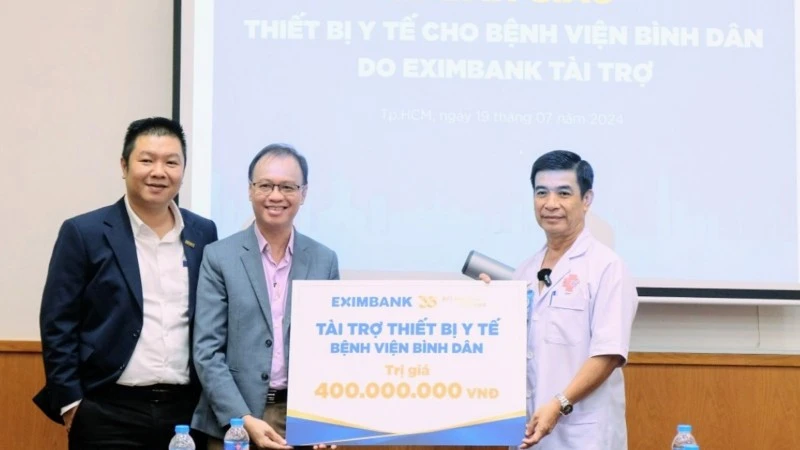 Ông Nguyễn Hồ Hoàng Vũ, Phó Tổng Giám đốc Eximbank (thứ 2 từ trái sang) trao tặng thiết bị y tế trị giá 400 triệu đồng cho ông Lương Thanh Tùng, bác sĩ chuyên khoa II, Phó Giám đốc Bệnh viện Bình Dân.