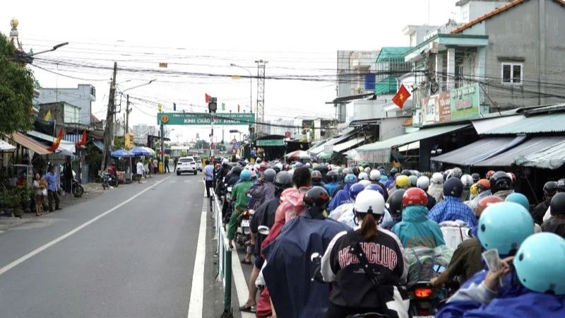 Người dân từ phía Đồng Nai xếp hàng dài qua phà Cát Lái di chuyển về Thành phố Hồ Chí Minh chiều 3/9. (Ảnh: QUÝ HIỀN)