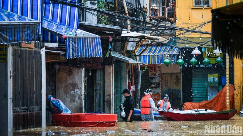 Di chuyển dân tại khu vực bị ngập lụt tới nơi an toàn. (Ảnh: Thành Đạt)