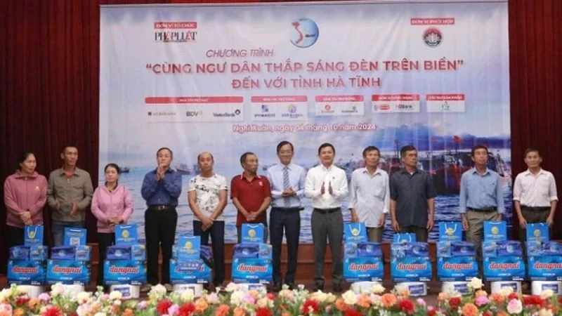 Đại diện lãnh đạo tỉnh Hà Tĩnh và báo Pháp Luật Thành phố Hồ Chí Minh trao quà cho bà con ngư dân. (Ảnh: ĐẶNG TRUNG)