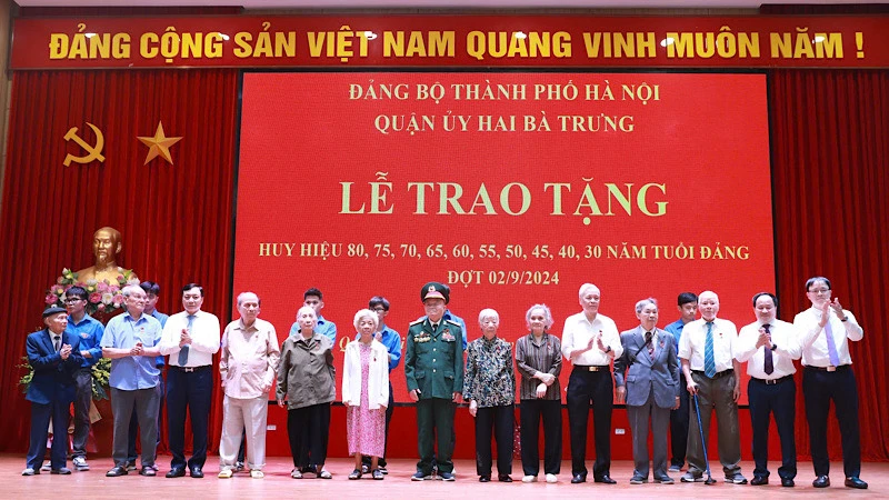 Đại diện Quận ủy Hai Bà Trưng trao tặng Huy hiệu Đảng và hoa chúc mừng 8 đồng chí đảng viên 75 năm, 70 năm tuổi đảng.