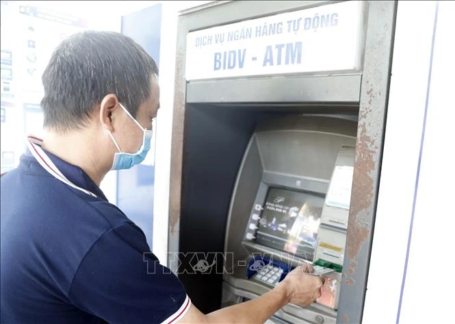 Người dân sử dụng thẻ nội địa tại máy rút tiền tự động của BIDV. (Minh họa: Trần Việt/TTXVN)