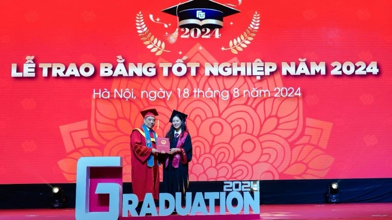 Hiệu trưởng Trường đại học Ngoại thương Phó Giáo sư, Tiến sĩ Bùi Anh Tuấn trao bằng tốt nghiệp cho thủ khoa tốt nghiệp Nguyễn Khánh Linh và các tân cử nhân. 