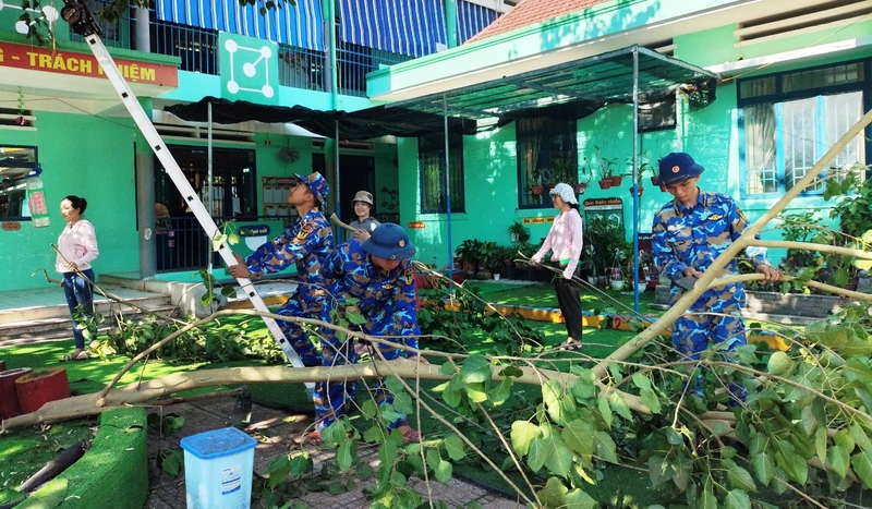 Cán bộ chiến sĩ Tiểu đoàn 863, Lữ đoàn 101 Hải quân giúp phát quang, thu dọn cây xanh trong sân trường.