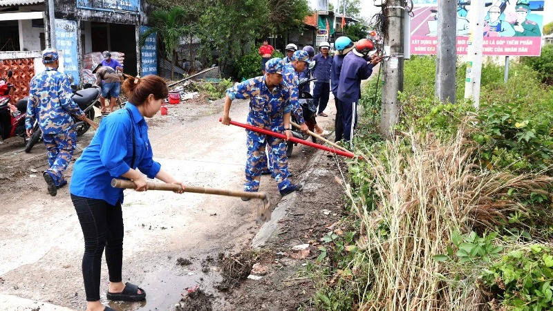 Cán bộ, đoàn viên thanh niên các đơn vị Hải quân và thanh niên địa phương dọn vệ sinh các tuyến đường giao thông ở xã Hàng Vịnh, huyện Năm Căn, tỉnh Cà Mau.