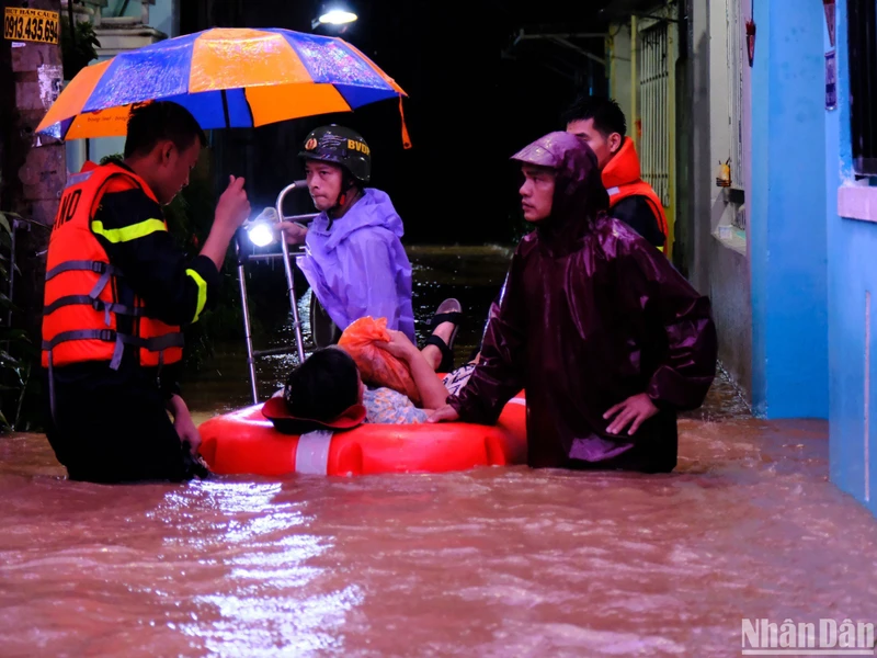 Lực lượng chức năng hỗ trợ sơ tán dân khu vực ngập lụt đường Mẹ Suốt, đêm 7/11. (Ảnh: ANH ĐÀO)