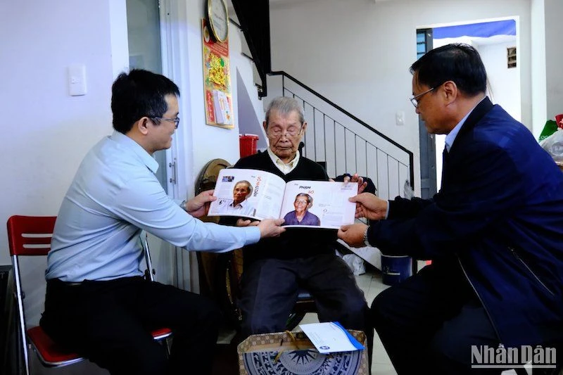 Nhân chứng Phạm Sô (ngồi giữa) nhận cuốn tư liệu Hoàng Sa từ ông Võ Ngọc Đồng, Giám đốc Sở Nội vụ, Chủ tịch Ủy ban nhân dân huyện Hoàng Sa. (Ảnh: ANH ĐÀO)
