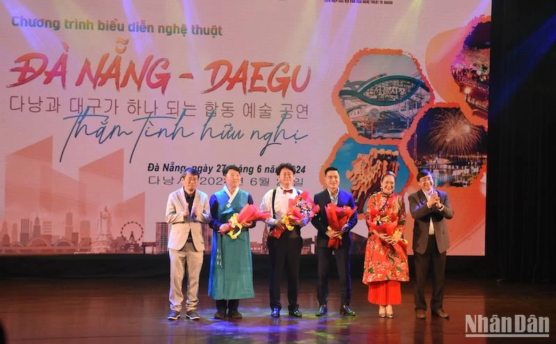 Ông Bùi Văn Tiếng, Chủ tịch Liên hiệp các Hội văn học nghệ thuật thành phố Đà Nẵng và Ông Lee Chang Hwan - Chủ tịch Liên hiệp các Hội Văn hóa nghệ thuật thành phố Daegu tặng hoa cho các nghệ sĩ. (Ảnh ANH ĐÀO)