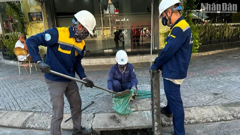 Công nhân khơi thông, nạo vét hệ thống thoát nước trên tuyến đường Lê Duẩn, quận Hải Châu, thành phố Đà Nẵng. (Ảnh: ANH ĐÀO)