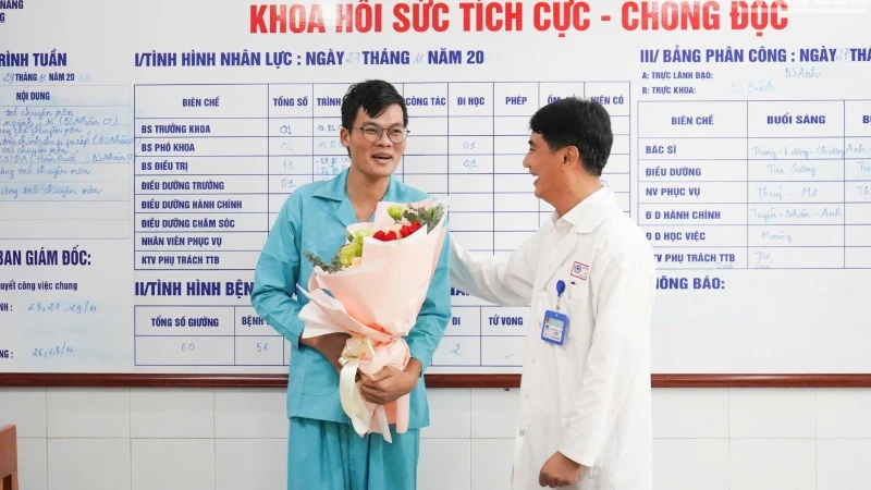 Tiến sĩ, bác sĩ Lê Đức Nhân, Giám đốc Bệnh viện Đà Nẵng tặng hoa, chúc mừng bệnh nhân, sáng 27/11. (Ảnh: ANH ĐÀO)