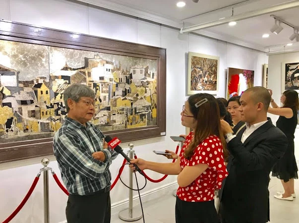 Hoạ sĩ Văn Chiến giới thiệu với báo chí và công chúng về các tác phẩm tại triển lãm.