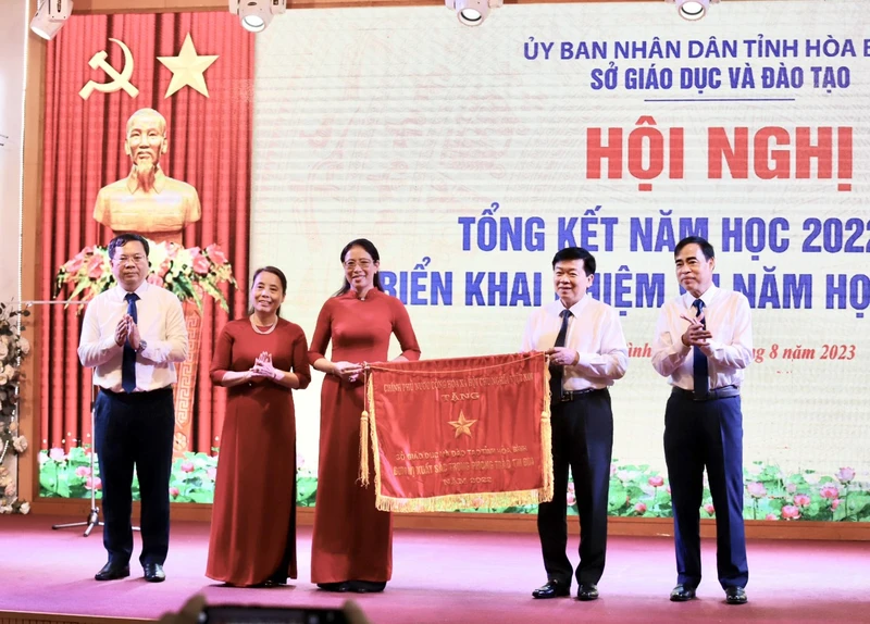 Đồng chí Nguyễn Văn Chương, Phó Chủ tịch Ủy ban nhân dân tỉnh Hòa Bình (thứ 2 từ trái sang) trao cờ thi đua của Thủ tướng Chính phủ cho ngành Giáo dục và Đào tạo tỉnh.