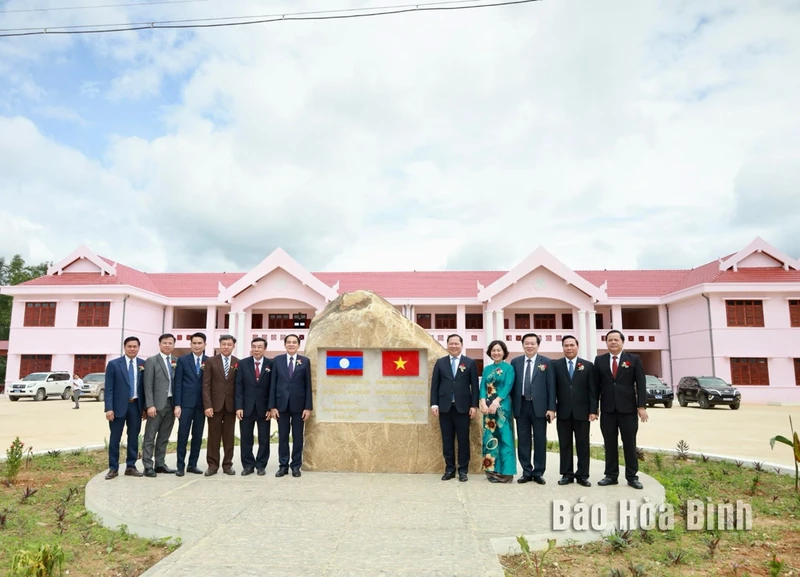 Lãnh đạo 2 tỉnh Hòa Bình và Hủa Phăn chụp ảnh lưu niệm tại biểu tượng tình hữu nghị Việt-Lào trên công trình Trường THPT huyện Hủa Mường. (Ảnh: BÙI MINH) 
