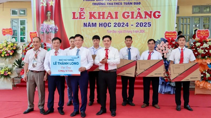 Phó Thủ tướng Lê Thành Long (phải) tặng 5 bộ máy vi tính cho Trường tiểu học và trung học cơ sở Tuân Đạo, huyện Lạc Sơn.