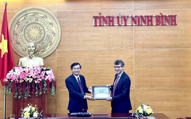 Đồng chí Đoàn Minh Huấn, Ủy viên Trung ương Đảng, Bí thư Tỉnh ủy Ninh Bình tặng quà lưu niệm cho ông Jonathan Baker, Trưởng Văn phòng đại diện của UNESCO tại Việt Nam. (Ảnh: YẾN TRINH)
