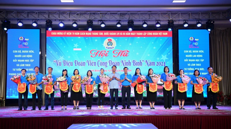 Đại diện của 13 đơn vị tham gia Hội thi nhận hoa và cờ lưu niệm của Ban Tổ chức. (ẢNH: TRƯỜNG GIANG)