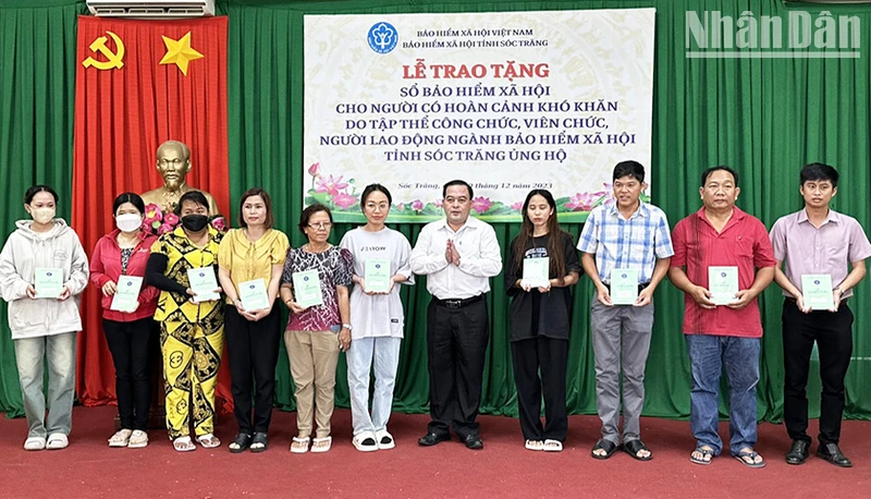 Phó Giám đốc BHXH tỉnh Sóc Trăng Lâm Thanh Thiên trao sổ BHXH cho các hộ khó khăn.
