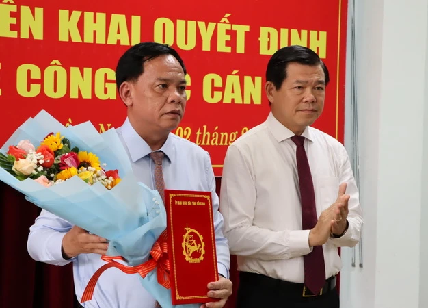 Bí thư Tỉnh ủy Đồng Nai Nguyễn Hồng Lĩnh trao quyết định và tặng hoa chúc mừng đồng chí Võ Tấn Đức.