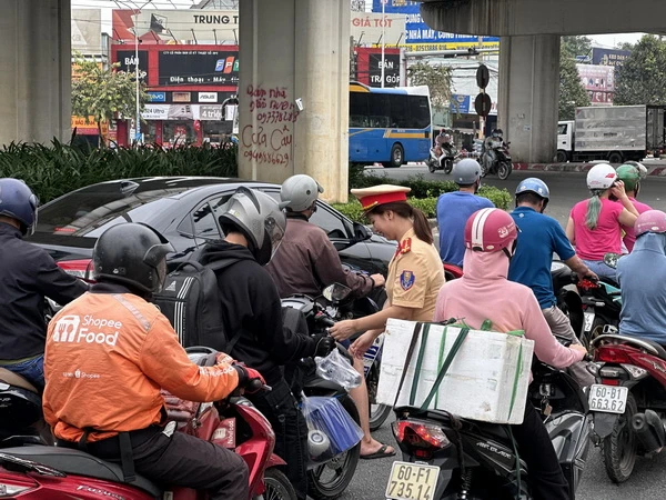 Nữ cảnh sát giao thông Công an tỉnh Đồng Nai phát nước suối cho người dân về quê đón Tết. 