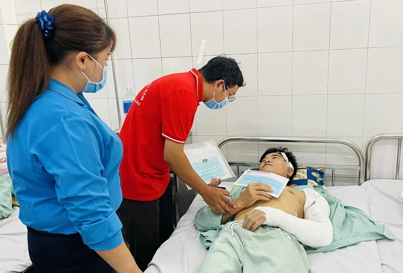 Đại diện Hội Chữ thập đỏ tỉnh Đồng Nai trao số tiền hỗ trợ công nhân bị thương.