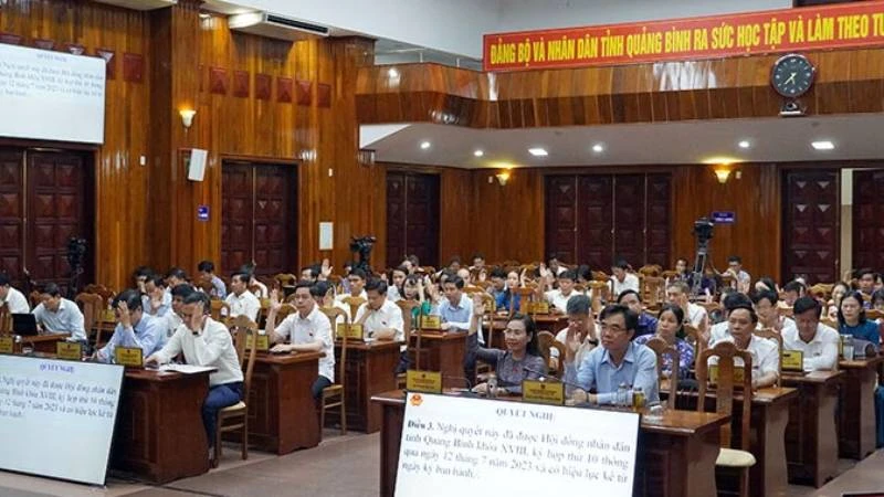 Các đại biểu Hội đồng nhân dân tỉnh Quảng Bình biểu quyết thông qua nghị quyết.