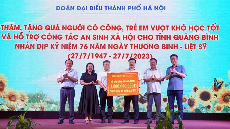 Ủy viên Bộ Chính trị, Bí thư Thành ủy Hà Nội Đinh Tiến Dũng trao hỗ trợ an sinh xã hội cho tỉnh Quảng Bình. (Ảnh Ngọc Mai)