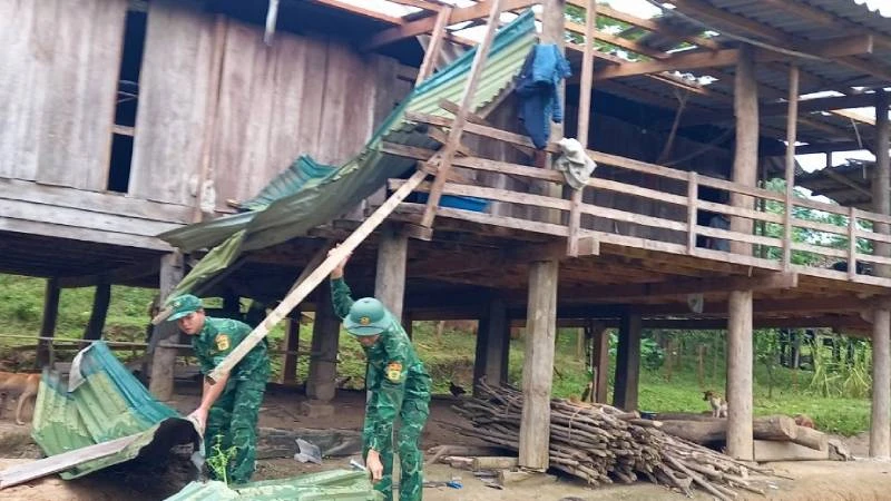 Cán bộ, chiến sĩ Đồn Biên phòng Ra Mai giúp bà con lợp lại nhà bị lốc xoáy làm hư hỏng.