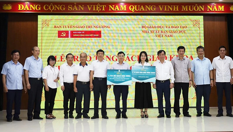 Đồng chí Phan Xuân Thủy và các đại biểu trao tặng sách giáo khoa cho học sinh khó khăn thông qua lãnh đạo Sở Giáo dục và Đào tạo. (Ảnh: Hiền Chi)