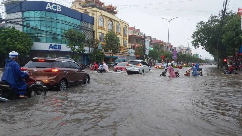 Đường Trần Hưng Đạo, tuyến đường chính của thành phố Đồng Hới ngập sâu một đoạn, gây khó khăn cho người và phương tiện qua lại.