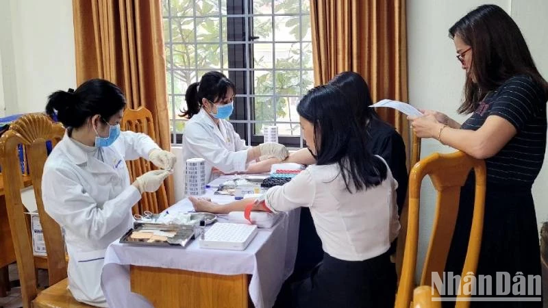 Nhân viên MEDLATEC Quảng Bình lấy mẫu xét nghiệm cho giáo viên một trường trung học phổ thông ở thành phố Đồng Hới.