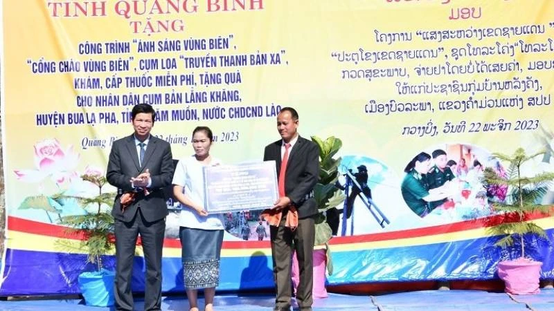 Đại diện lãnh đạo Ủy ban nhân dân tỉnh Quảng Bình trao bảng tượng trưng các công trình dân sinh tặng cho cụm bản Lẳng Khăng (Lào)