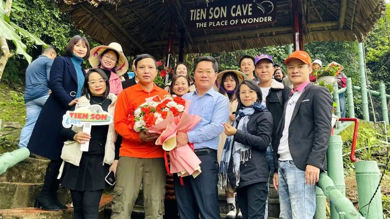 Giám đốc Trung tâm Du lịch Phong Nha-Kẻ Bàng Hoàng Minh Thắng tặng hoa những du khách đầu tiên tham quan động Tiên Sơn sau ngày mở cửa trở lại.